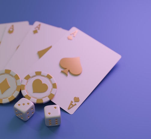 A set of playing cards displaying four aces is laid out on a surface. Alongside them, there are two poker chips with heart and diamond symbols, and three six-sided dice showing different numbers. The background is a smooth gradient of purple, creating a thematic gaming or casino atmosphere.