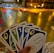 A hand holding a set of colorful cards with numbers and symbols, set in an indoor environment decorated with warm yellow string lights and a blurred background of various objects.